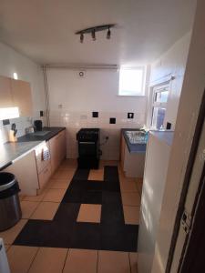 a small kitchen with a black and white floor at Center Place - Near Derby City Center in Derby