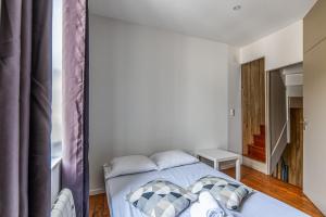 een slaapkamer met een bed in een kamer met een raam bij Lovely city house in the heart of Honfleur - Welkeys in Honfleur
