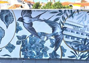 a mural of two birds on a wall at Hotel Baia in Cascais
