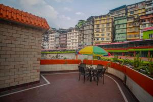 a table with a yellow and green umbrella on a balcony at Central Hill Resort The Mall Road in Gangtok