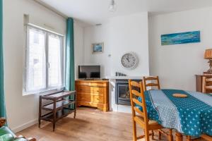 Cette chambre dispose d'une table, d'une télévision, d'une table et de chaises. dans l'établissement Maison Flatelle - Welkeys, à Trouville-sur-Mer 6 autres photos