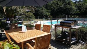 mesa de madera con parrilla y mesa con sillas en maison de plain pied a 1 km de la mer , avec piscine securisée, en Fouesnant