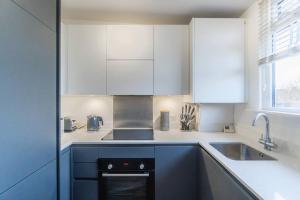 a kitchen with white cabinets and a sink at PRIME SPOT FOR ASCOT & WINDSOR - 2 BEDROOMS in Ascot
