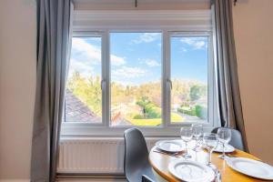 una mesa con copas de vino y una gran ventana en PRIME SPOT FOR ASCOT & WINDSOR - 2 BEDROOMS en Ascot