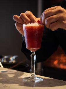 a person is adding a cherry to a cocktail at Hotel Baia in Cascais
