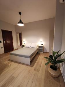 a bedroom with a bed and a potted plant at Villa Elea Apartments in Spiliá