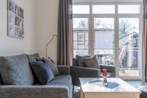 een woonkamer met een bank en een groot raam bij Villa Marin Wohnung 16 in Zinnowitz