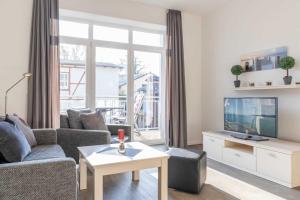 een woonkamer met een bank en een tv bij Villa Marin Wohnung 16 in Zinnowitz