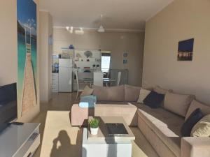 uma sala de estar com um sofá e uma mesa em Anada apartament em Saranda