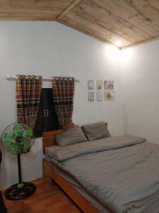 a bedroom with a bed and a table and curtains at Homestay Hoàng Vũ in Ha Giang