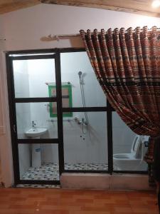 a bathroom with a shower and a toilet and a window at Homestay Hoàng Vũ in Ha Giang