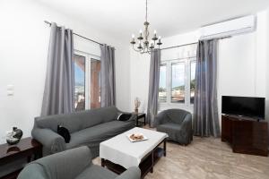 a living room with a couch and a tv at MTC-D Apartments by the Sea and Airport in Porto Rafti