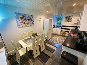 a kitchen with a table and chairs and a refrigerator at Paisley Pad: Glasgow Gateway in Paisley