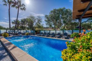 a swimming pool with lounge chairs and palm trees at Ideal Property Mallorca - Son Morei Gran in Muro