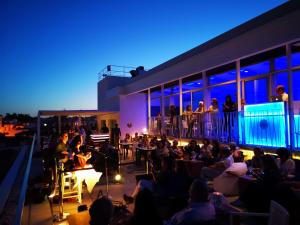 a crowd of people sitting on a balcony at night at Hotel Baia in Cascais +37 photos
