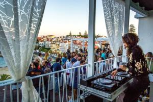 a woman standing on a balcony with a crowd of people at Hotel Baia in Cascais