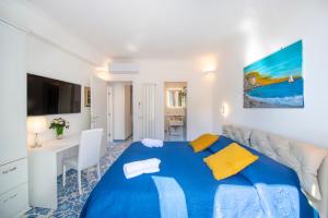 a bedroom with a blue bed and a desk at Casa Diodora, Costiera Amalfitana in Maiori