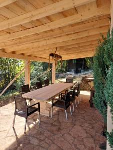 une table et des chaises en bois sous un toit en bois dans l'établissement Planinska kuća HIL - Bjelašnica, à Sarajevo