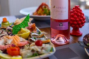 a bottle of wine sitting next to a plate of food at Hotel Riva Del Sole in Cefalù
