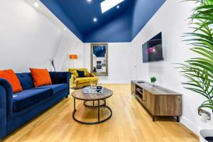 uma sala de estar com um sofá azul e uma mesa em Spacious Contemporary 2 bed flat, Central London em Londres