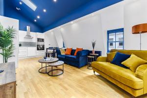 uma sala de estar com um sofá amarelo e uma mesa em Spacious Contemporary 2 bed flat, Central London em Londres