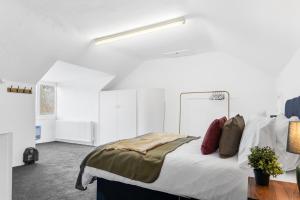 a bedroom with a large bed with white walls at Lovely Central Loughborough Abode - Games Room in Loughborough