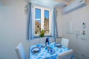 - une table bleue et blanche avec une fenêtre dans la chambre dans l'établissement Casa Diodora, Costiera Amalfitana, à Maiori