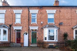 a brick house with a green door and white windows at Lovely Central Loughborough Abode - Games Room in Loughborough