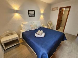 - une chambre avec un lit bleu et des serviettes dans l'établissement Beautiful Sunset Apartment, à Puerto de Santiago