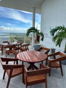 a patio with wooden tables and chairs with a view at Flat Paiva Home Stay in Recife