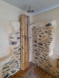 La salle de bains est pourvue d'une douche et d'un mur en pierre. dans l'établissement Gîte des Forges, à Saint Lo