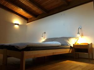 a bedroom with a bed with two lights on the wall at Willa no.18 in Reda