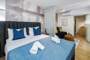 Un dormitorio con una cama azul y blanca con almohadas azules en Skalinada Sea View en Lokva Rogoznica