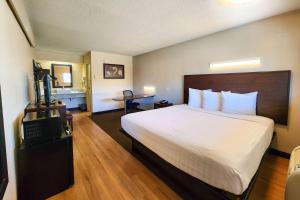 a hotel room with a large bed and a television at Travelodge by Wyndham Peoria in Peoria