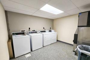 a laundry room with four washers and dryers in it at Travelodge by Wyndham Peoria in Peoria