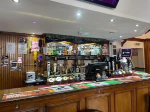 eine Bar mit vielen Flaschen Alkohol in der Unterkunft The Swan Inn in Henwick