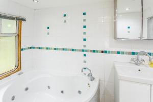 a white bathroom with a tub and a sink at Carriage 1 - Coalport Station Holidays in Telford +9 photos