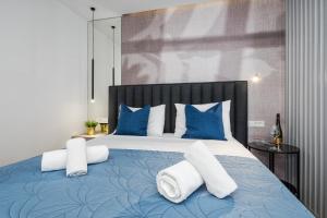 1 dormitorio con 1 cama grande con almohadas azules y blancas en Skalinada Sea View en Lokva Rogoznica