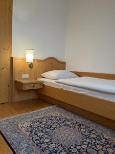 - une chambre avec un lit doté d'une lampe et d'un tapis dans l'établissement Pension Buch, Bed and Breakfast, à Eberau