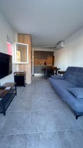 ein Wohnzimmer mit einem blauen Sofa und einem Tisch in der Unterkunft le cabanon in Roquebrune-Cap-Martin