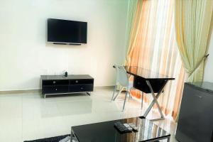 uma sala de estar com uma televisão e uma cadeira em Rumens Apartment em Lagos