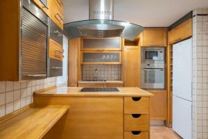 cocina con armarios de madera, fregadero y fogones en For You Rentals Central Apartment Atocha Station Madrid TEL3 en Madrid