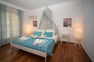 una camera con letto blu e bianco di Avlaki Beach House,stylish villa in Kassiopi a Kassiopi