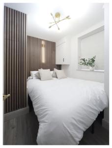 een witte slaapkamer met een groot wit bed. bij SoulFul Stays Chelmsford in Broomfield