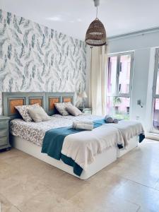 1 dormitorio con 1 cama grande y un mural en la pared en Aquamarine apartment in Marina Sotogrande, en Torreguadiaro