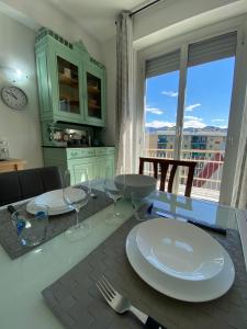 a dining room table with plates and wine glasses at Appartamenti Azzurro Smeraldo in Sestri Levante