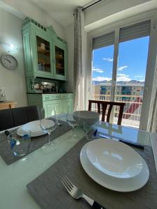 tavolo da pranzo con piatti e bicchieri da vino di Appartamenti Azzurro Smeraldo a Sestri Levante