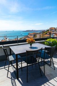 a table and chairs on a balcony with a view of the ocean at Ando Living - Taksim Gumussuyu Townhouse in Istanbul