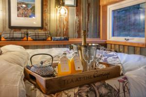 a tray with a bottle of wine and glasses on a bed at The Carriage at Creagan in Creagan