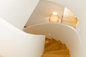 eine Treppe in einem Haus mit weißen Wänden und Holzböden in der Unterkunft Ando Living - Taksim Gumussuyu Townhouse in Istanbul